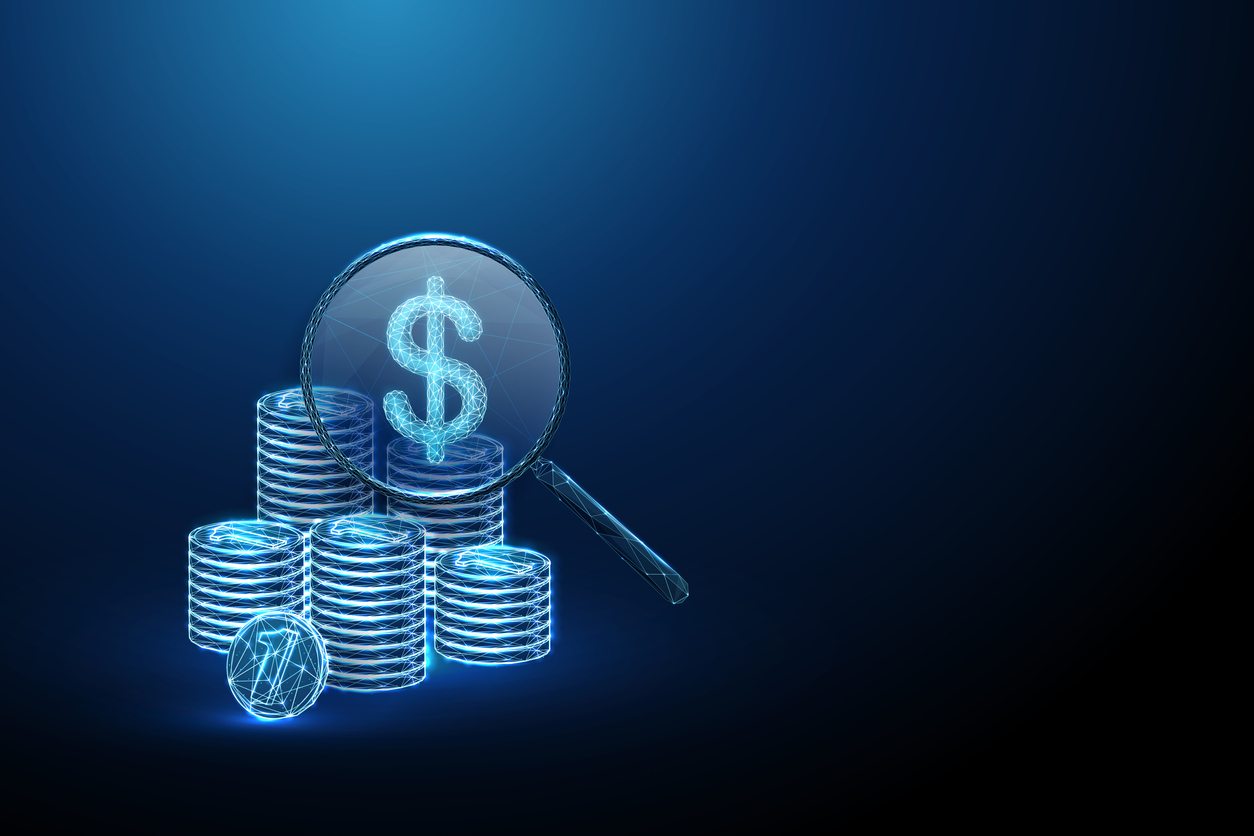 Magnifying glass over stack of crypto coins by Alena Butusava through iStock.